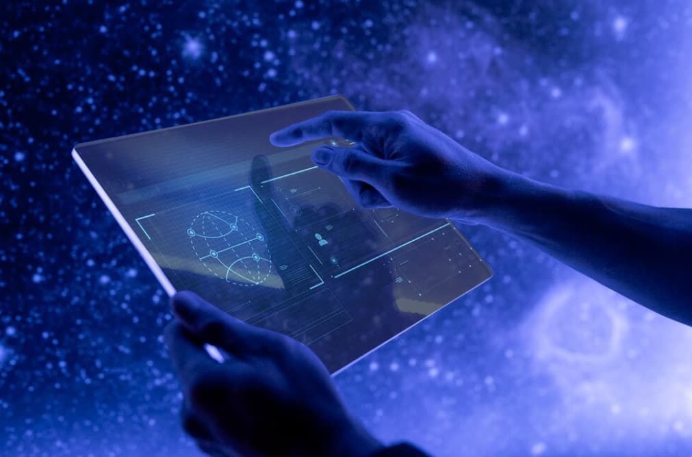 Hands interacting with a transparent tablet, showcasing advanced technology in a cosmic environment